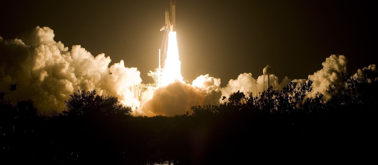 Space shuttle Endeavour lifting off at night from Kennedy Space Center